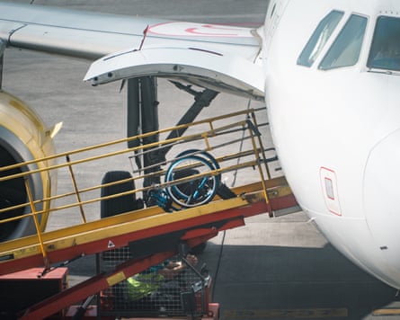 A wheelchair on a ramp going into the hold of a plane
