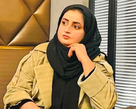 Liza Shams, in a headscarf and coat, sits with her hand near her chin