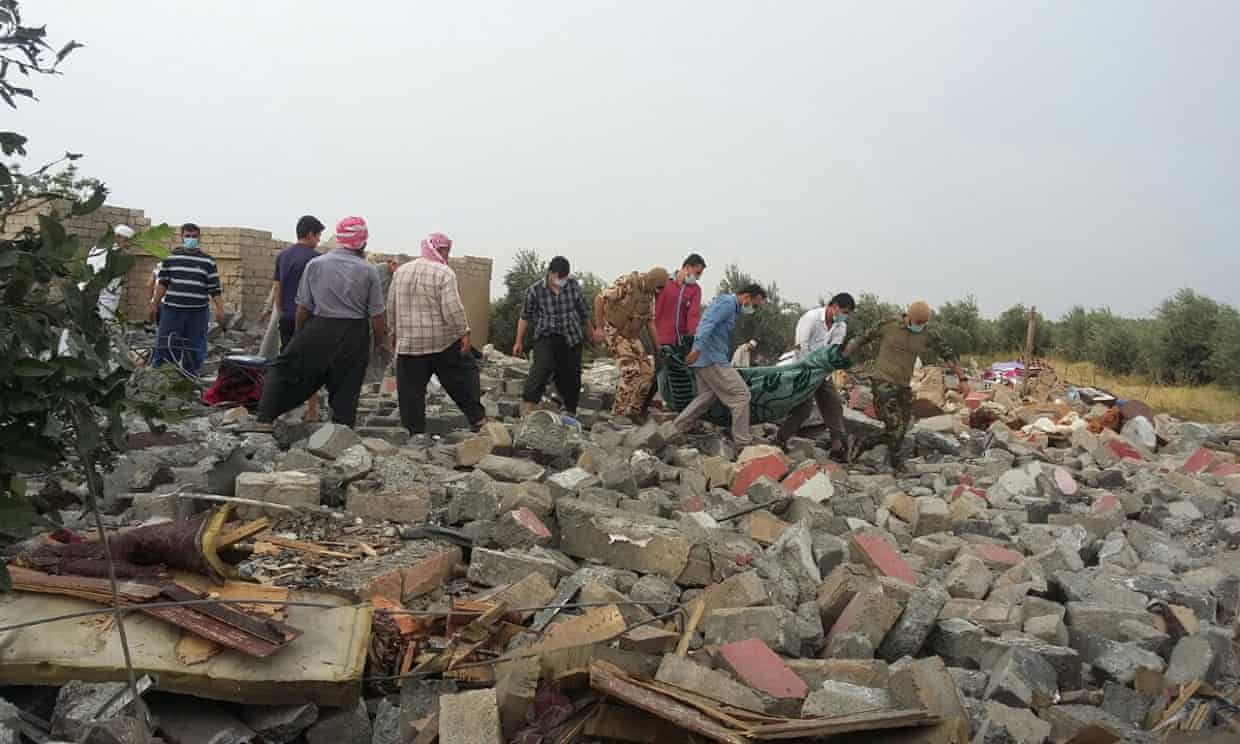 Људи носе тела након ваздушног напада у селу Фадилија у близини Мосула. Осам цивила, укључујући троје деце, убијено је у ваздушном нападу САД на њихову кућу у близини Мосула. Фотографија: Фазел Хаврами за Гуардиан