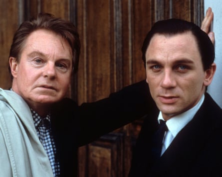 Jacobi and Graic standing close together in front of a wooden door