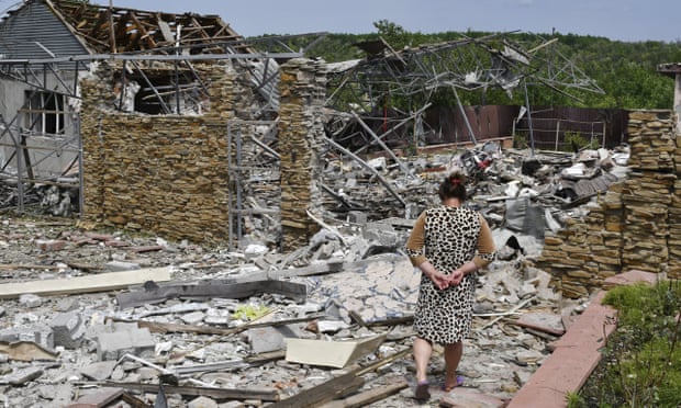 A woman walks next to a building damaged by a missile strike in Sloviansk, Ukraine