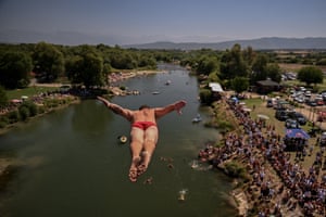 A distant crowd watch from the shore as a driver jumps away from camera towards the White Drin River.