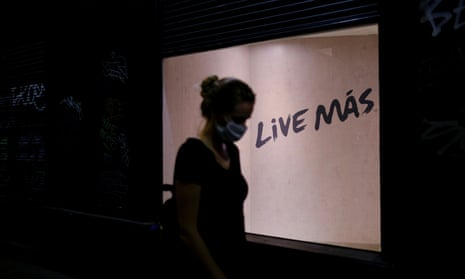 A woman walks past a sign reading “Live More” on a street in Barrio Gotico after Catalonia’s regional authorities announced restrictions to contain the spread of Covid-19 in Barcelona, Spain.