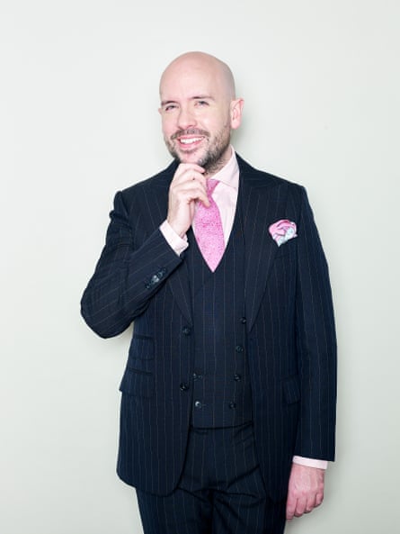 Portrait of Tom Allen wearing a pinstriped suit and a pink tie