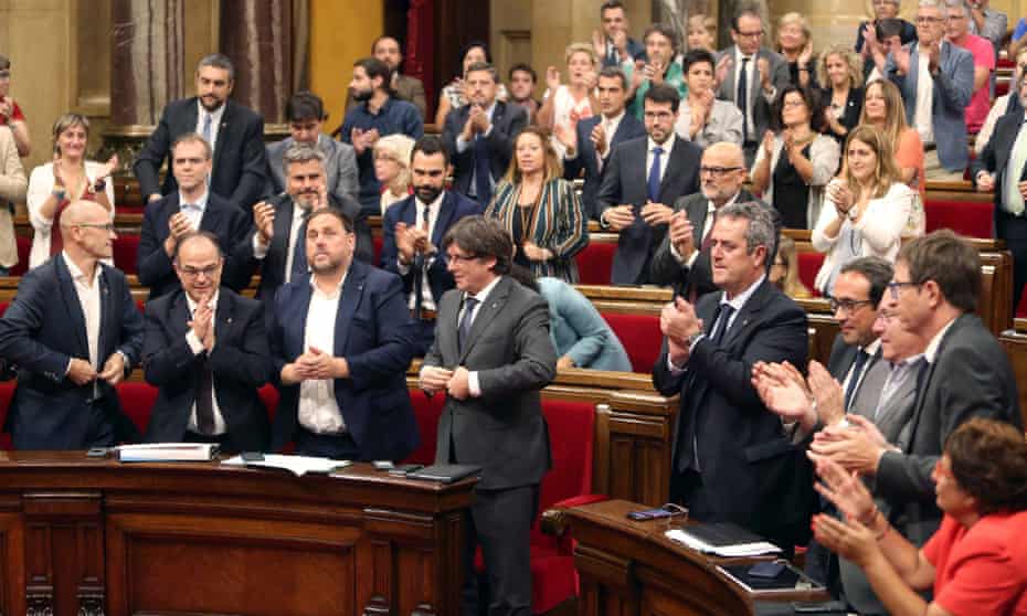 Catalan regional president, Carles Puigdemont (fourth from left) applauds with MPs after a referendum law was approved by the Catalonian parliament.