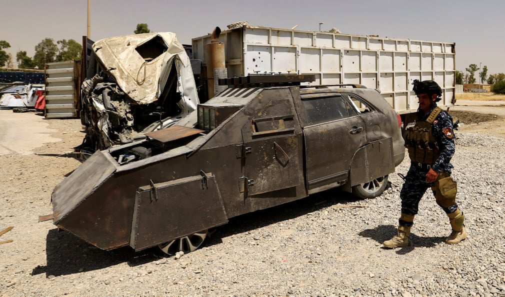A police officer walks past a suicide bomb car