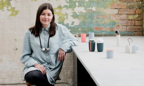 Aimee Bollu sitting beside a table with examples of her pots on it