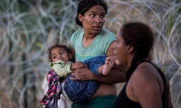 A woman carries her child after she and other migrants crossed the Rio Grande and entered the U.S. from Mexico, to be processed by U.S. Customs and Border Protection, Saturday, Sept. 23, 2023, in Eagle Pass, Texas. The image was part of a series by Associated Press photographers Ivan Valencia, Eduardo Verdugo, Felix Marquez, Marco Ugarte Fernando Llano, Eric Gay, Gregory Bull and Christian Chavez that won the 2024 Pulitzer Prize for feature photography. (AP Photo/Eric Gay)