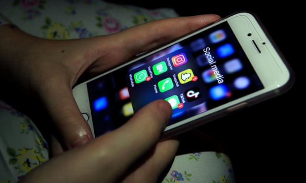 Young girl looking at social media apps on a smartphone