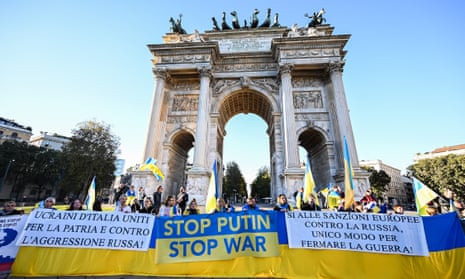 People hold flags during a rally in support of Ukraine at Arco Della Pace in Milan, Italy.
