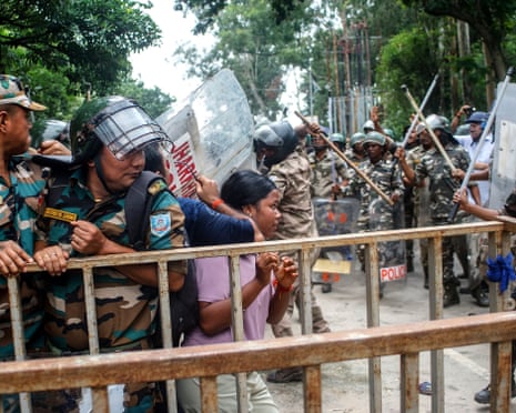 Security personnel restrain a protester near a barricade