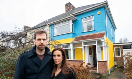 Rend Platings and her husband Michael outside their home in Cambridge, which they have painted in the colours of the Ukraine flag in a show of support for friends in the country.