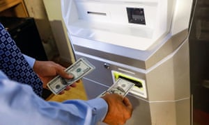 A man feeds money into a Bitcoin machine in New York, US.