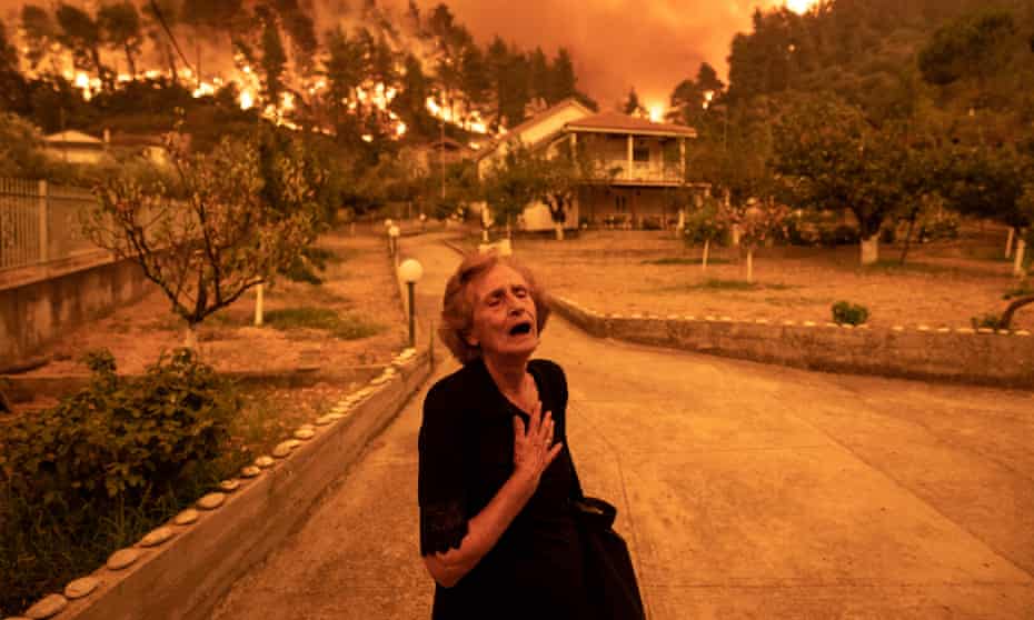 Wildfire approaches a woman’s house on the island of Evia, Greece, August 2021. 