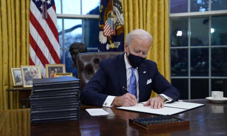 Joe Biden signs an executive order on 20 January. The White House has called the Covid relief bill ‘the most progressive legislation in history’.