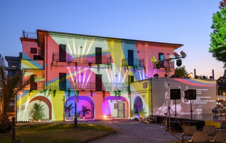 Villa Mussolini exterior lit by colourful lights with a stage in the garden