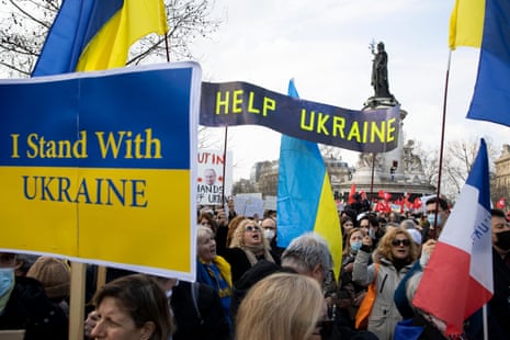 Protesters hold signs of support for Ukraine.