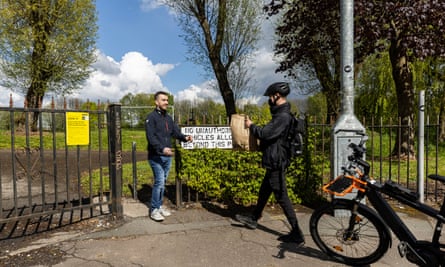 Student Tyler Kernick, 25, receives his shopping from Weezy rider Matthew Wright in a park as he livesjust outside the delivery area in Salford.