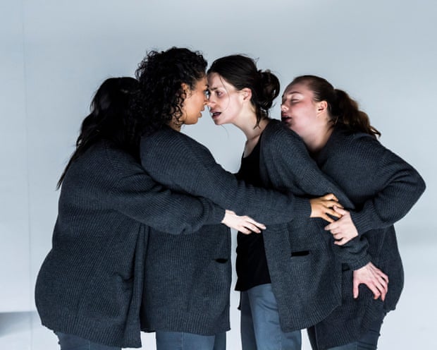 Actors from 4.48 Psychosis huddle in matching grey cardigans, faces close, in emotional embrace