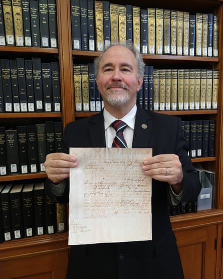 David Allen Lambert, holding a copy of his ancestor Mary Bradbury’s indictment for witchcraft in Salem in 1692.