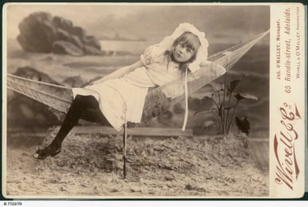 A young girl dressed in white reclines on a hammock