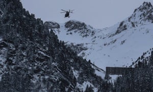 A helicopter flies to the site of the avalanche near Valfréjus