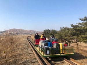 Russian diplomats and family members use a hand-pushed rail trolley to leave North Korea amid coronavirus restrictions while crossing the demarcation line between North Korea and Russia.