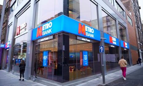 Two people outside Metro Bank branch on the corner of a street