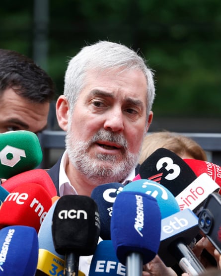 Fernando Clavijo speaks into a cluster of media-branded microphones