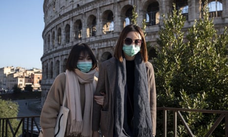 Tourists wearing face masks visit the Colosseum area in Rome, where England are scheduled to play on 14 March.