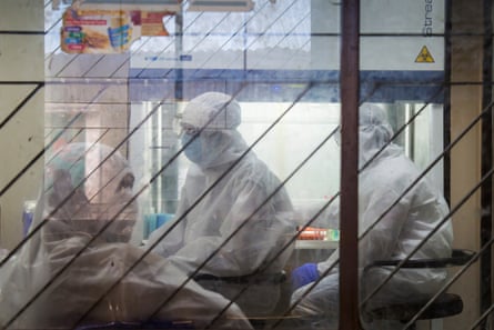 Health workers in white protective suits collect coronavirus samples at a local hospital in Dhaka