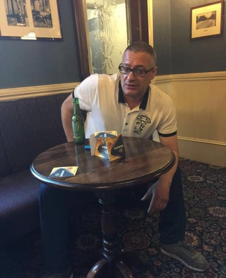 Roy Larner sitting at a pub table with a bottle of beer