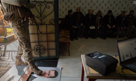 A man steps on a photo of Assad laid in a doorway