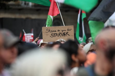 A protester holds a placard with a message reading ‘Shame on your Keir Starver’