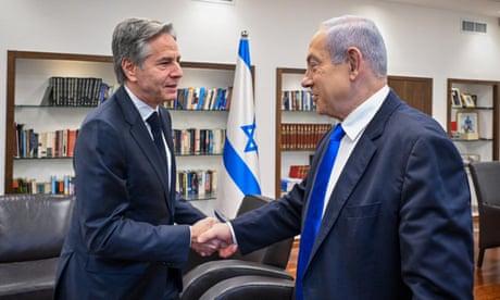 Antony Blinken shaking hands with Benjamin Netanyahu in a room containing bookshelves and an Israeli flag