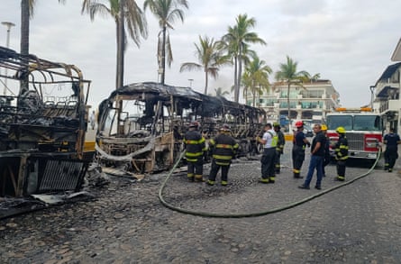 Firefighters work in Puerto Vallarta where buses were set on fire by criminal gangs.