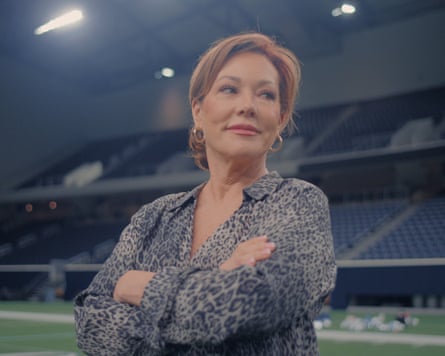 Woman stands on football pitch with arms folded