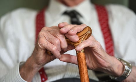 Elderly man's hands cradle walking stick