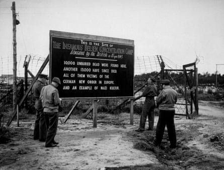 Soldiers stand before a sign at the site of the Bergen-Belsen concentration camp, which was burnt to the ground to combat the spread of typhus.