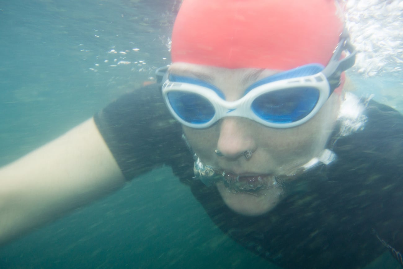 An underwater image of Teri in goggles and a red swimming cap