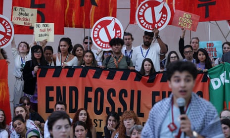Protesters hold placards and banners campaigning against fossil fuels