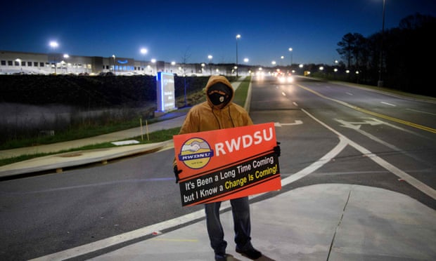 A union supporter stands before sunrise outside the Amazon fulfillment center in Bessemer, Alabama, in March.