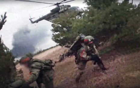 This video grab taken from a handout footage released by the Russian Defence Ministry shows Russian paratroopers taking control of an undisclosed airfield in Ukraine, according to the Russian Defence Ministry.