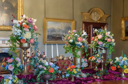 A floral table display, featuring faux flowers, butterflies and birds’ nests
