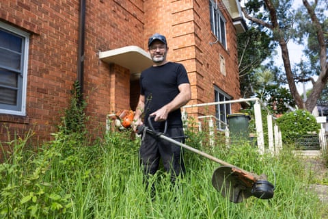Nathan Stafford holds a whipper snipper in an overgrown garden