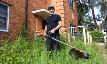 Nathan Stafford holds a whipper snipper in an overgrown garden