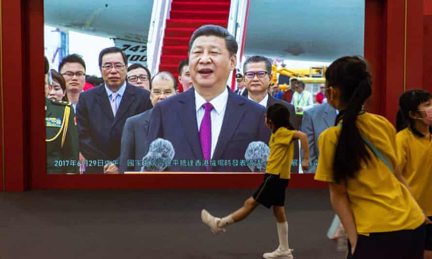 Hong Kong tightens security ahead of Xi visit for 25th anniversary of handover | Hong Kong 1 Students walk in front of a television screen displaying the footage of Xi Jinping’s previous visit at a handover exhibition ahead of the 25th anniversary of the Hong Kong handover