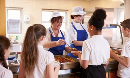 Dinner ladies serving children in a school cafeteria