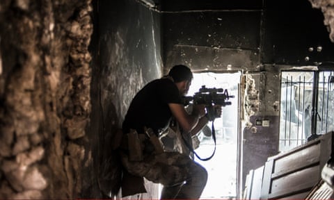 An Iraqi soldier fires at an Isis militant in Mosul, Iraq.