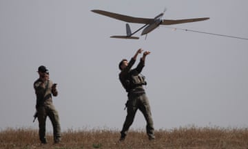 Israeli soldiers lift a drone near the border with Gaza 